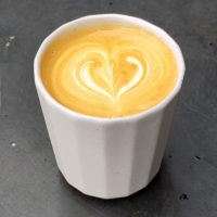 A flat white in my white ceramic cup, served at Code Black Coffee, Queensbridge Square